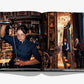 An Assouline book opens to show a bartender pouring a drink and two men at a bar, all set in the elegant, dimly lit ambiance of The Peninsula London, the luxury hotel near Hyde Park.
