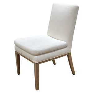 The Ferrell Mittman Decker Side Chair offers refined seating with custom upholstery, a cushioned seat, and wooden legs, shown against a plain white background.