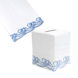 The Scrollfish Bath Collection in Dark China Blue by Haute Home includes a white Italian linen tissue box cover and matching napkin, both hand-embroidered with blue fish patterns along the edges.