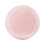 A round, pink item from Baobab's Paris Body Wellness Collection, with a raised Eiffel Tower pattern and ridged edge—blending Parisian charm, delicate chestnut blossom, and refined fragrance.
