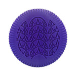 The Baobab Collection Manhattan Body Wellness Collection by Baobab features a round, purple item with a ridged edge and embossed geometric pattern, inspired by the fresh scent of Central Park.
