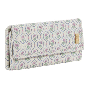 The TRVL Design Luxe Jewelry Wallet features a rectangular shape, pastel floral pattern, fold-over flap, and gold-tone metal label—making it the ideal travel jewelry organizer.