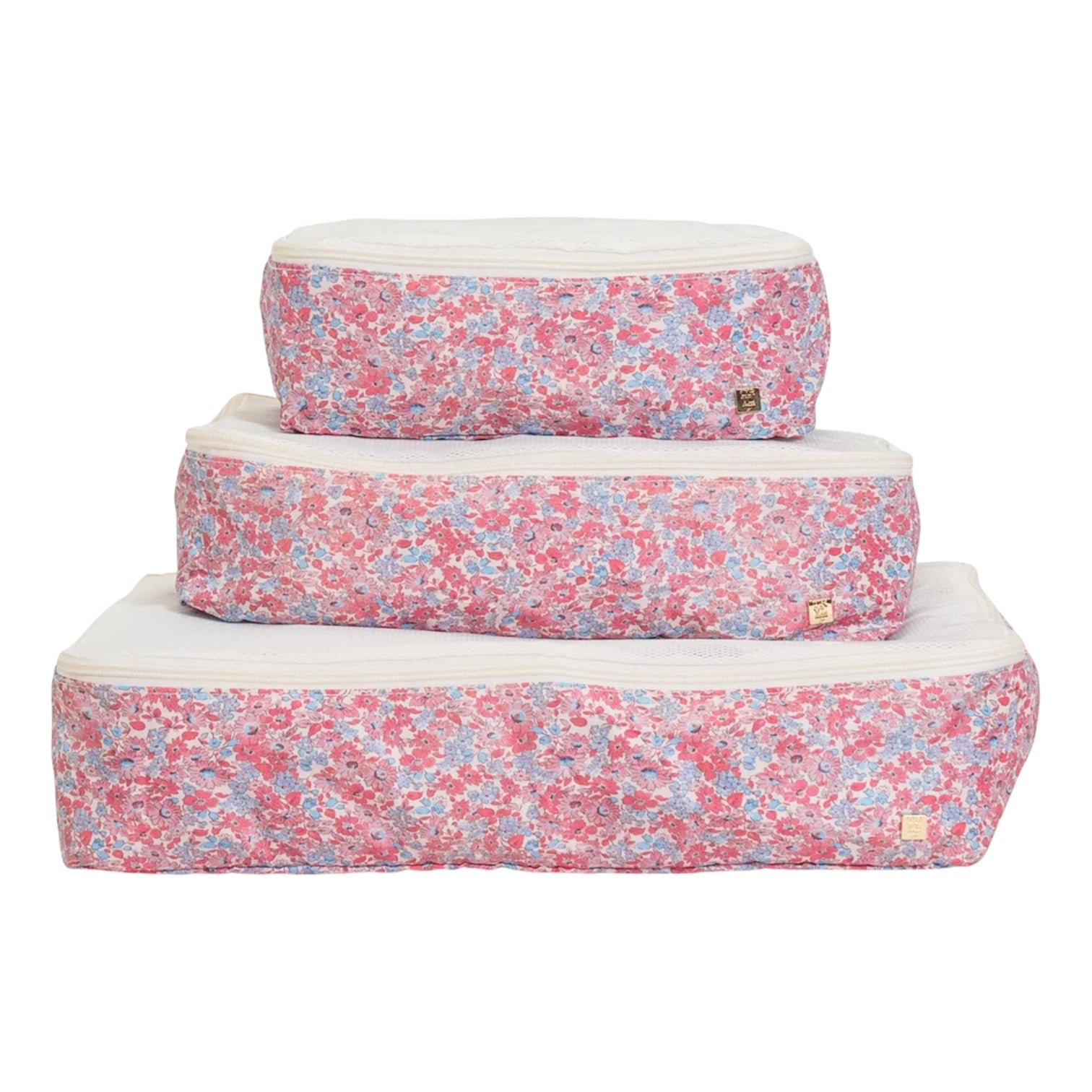 The Luxe Packing Cube Set of 3 by TRVL Design features small, medium, and large cubes with pink and blue floral patterns and white mesh zippered tops—ideal travel organizers for lightweight luggage.