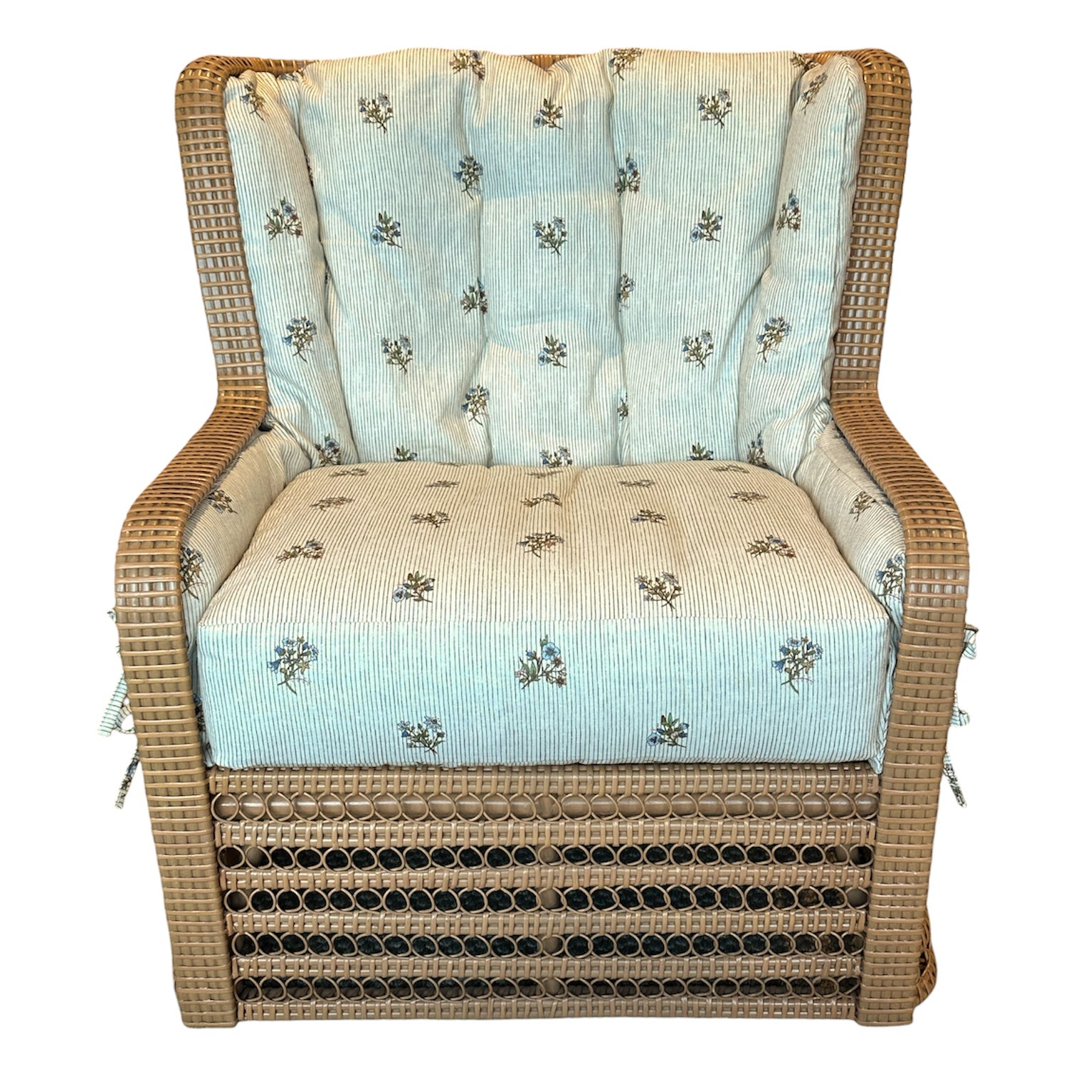 The Kinley Arm Chair by Bunny Williams features expert wicker craftsmanship, a boxy shape, and light blue floral tufted cushions for an ideal mix of comfort and style.