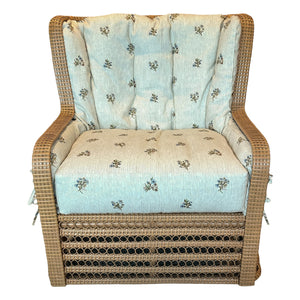 The Kinley Arm Chair by Bunny Williams features expert wicker craftsmanship, a boxy shape, and light blue floral tufted cushions for an ideal mix of comfort and style.