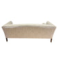 Back view of the Norman Sofa in Tinto by Ferrell Mittman, showcasing elegant beige tinto upholstery, a gently curved silhouette, and refined wooden legs.