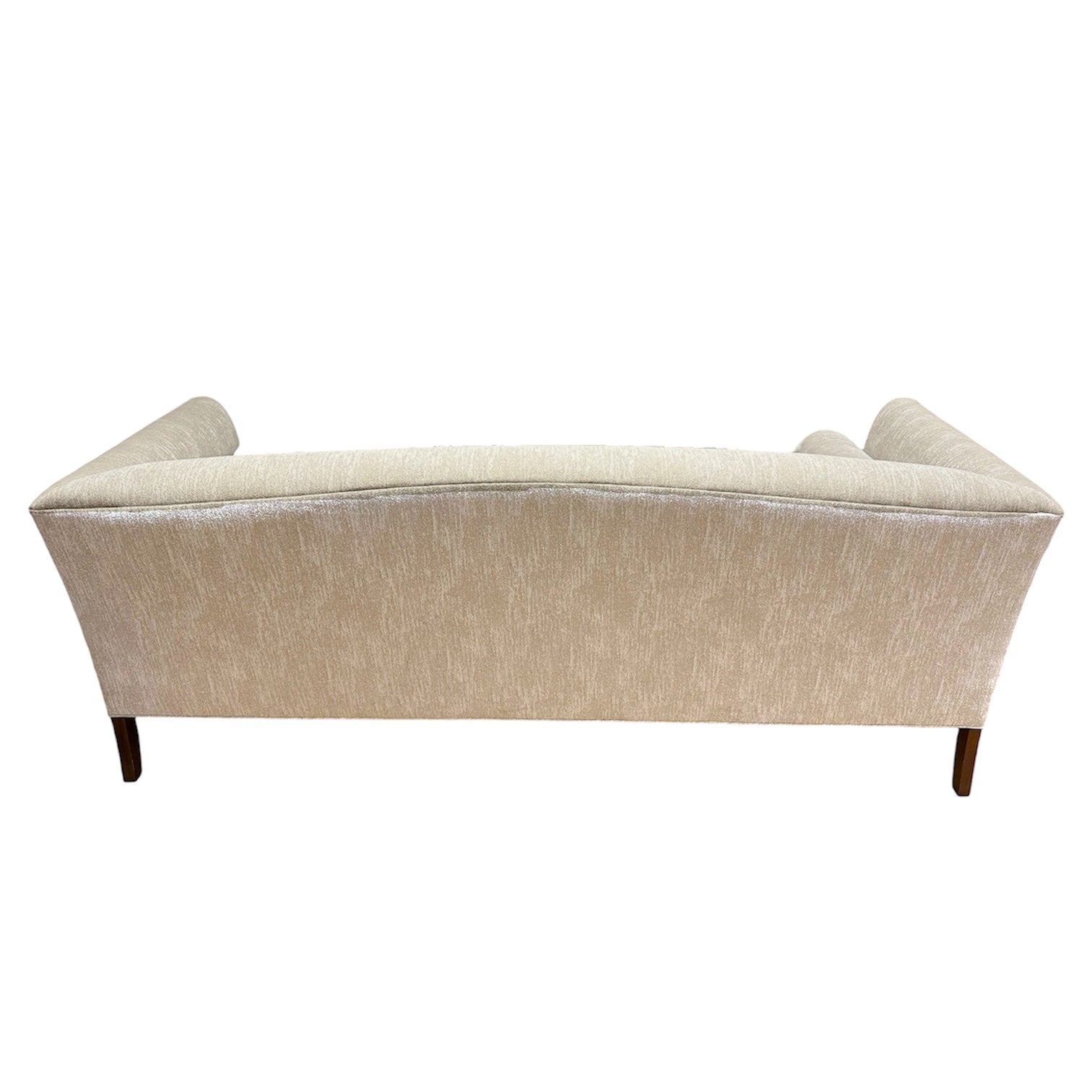 Back view of the Norman Sofa in Tinto by Ferrell Mittman, showcasing elegant beige tinto upholstery, a gently curved silhouette, and refined wooden legs.