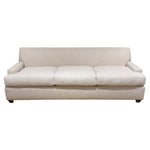 The Baker Yves Sofa is a beige, three-cushion luxury piece featuring a low backrest and armrests, upholstered in textured fabric and shown against a white background.
