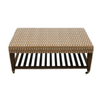 The Lee Industries Upholstered Cocktail Ottoman features a brown and white arrowhead-patterned cushion, wooden legs, a slatted lower shelf, and small wheels on one side.