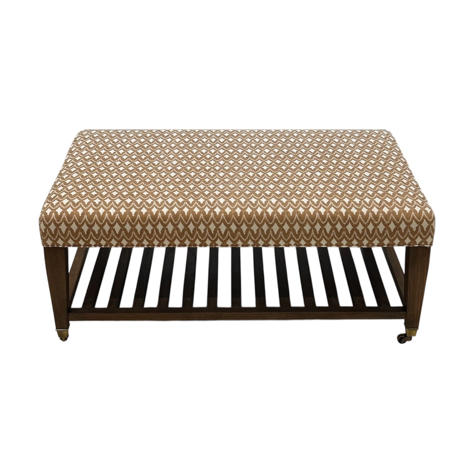 The Lee Industries Upholstered Cocktail Ottoman features a brown and white arrowhead-patterned cushion, wooden legs, a slatted lower shelf, and small wheels on one side.