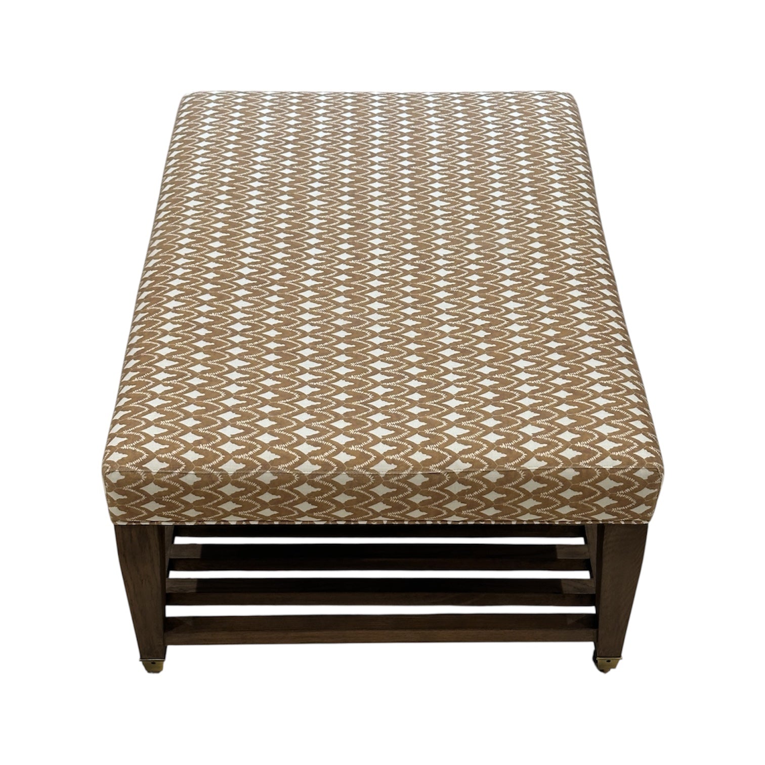 The Lee Industries Upholstered Cocktail Ottoman features a brown and white arrowhead pattern cushion, a rectangular shape, and a dark wooden base with a slatted shelf underneath.