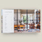 An open book—Pietro Cicognani: Architecture and Design by Common Ground—displays a table of contents on the left page and, on the right, a beautifully illuminated home interior with wooden furnishings and decor, evoking the warm ambiance found in Cicognani’s celebrated country house designs.