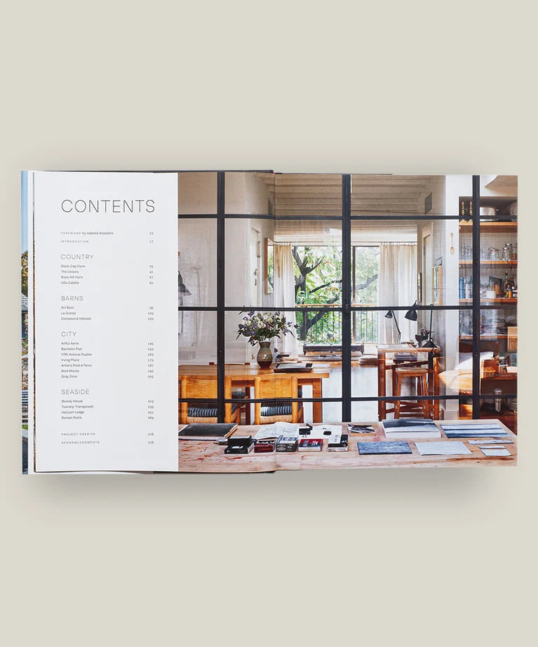 An open book—Pietro Cicognani: Architecture and Design by Common Ground—displays a table of contents on the left page and, on the right, a beautifully illuminated home interior with wooden furnishings and decor, evoking the warm ambiance found in Cicognani’s celebrated country house designs.