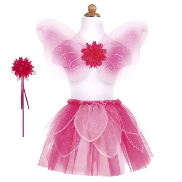 The Great Pretenders Fancy Flutter Skirt, Wings & Wand displayed on a mannequin is a child-sized pink fairy costume that includes wings, a flower on the bodice, a petal-like skirt with glitter petals, an elastic waist for comfort, and a matching flower wand.