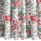 Close-up of a white curtain from Matouk’s Pomegranate Shower Curtain Collection, featuring a colorful botanical floral and leaf print in red, green, blue, and pink tones.