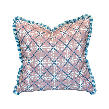 The Porto Pool Pillow by Hive Custom Pillows features a pink and white geometric floral design with blue diamond grid lines, blue fringe trim, and a plush 100% down-filled insert for comfort.