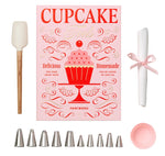 The Essentials Cupcake Tools by PrintWorks includes a spatula, recipe booklet, piping tips, a rolled cloth with a pink ribbon, and a pink cupcake liner—all stylishly displayed on a white background.