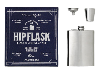 The Essentials Hip Flask by PrintWorks includes a stainless steel flask, metal shot glass, and funnel, presented with navy packaging. A sleek gift set for any occasion.