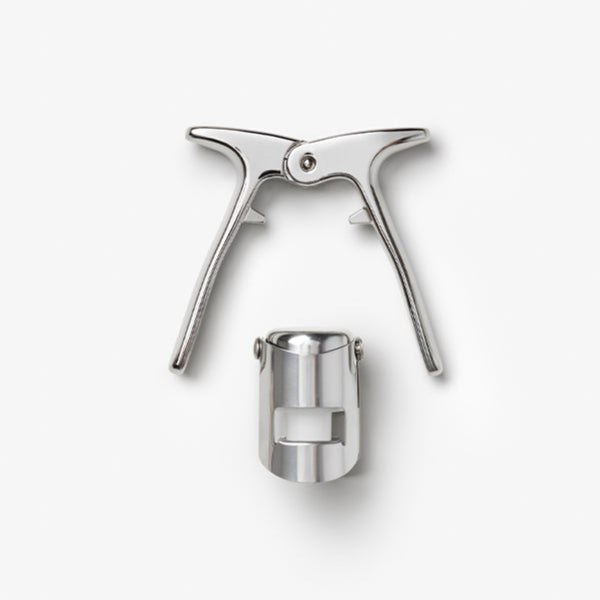 The Essentials Champagne Tools by PrintWorks, featuring two handles and a separate cylindrical attachment, are displayed on a plain white background.