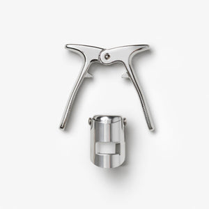 The Essentials Champagne Tools by PrintWorks, featuring two handles and a separate cylindrical attachment, are displayed on a plain white background.