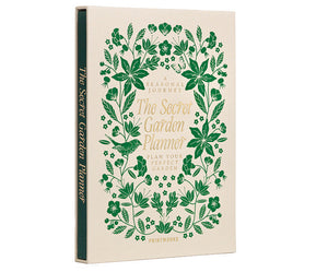 The PrintWorks Secret Garden Journal is a hardcover gardening planner with green floral designs on a beige cover, shown upright and slightly angled left. Ideal as a plant tracker or garden journal.