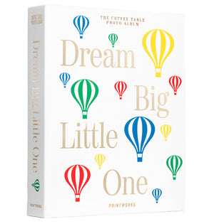 The PrintWorks Dream Big Little One Photo Album features a white cover with colorful hot air balloons and the phrase "Dream Big Little One"—ideal for preserving baby memories and displaying as a stylish coffee table album.