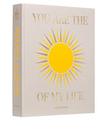 The PrintWorks "You Are The Sunshine Of My Life" photo album features beige covers with gold text and a sun illustration—an elegant coffee table piece that adds charm to your home decor.