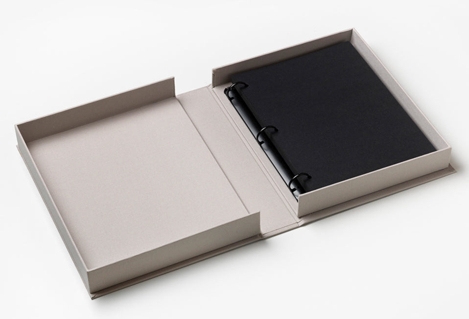 An open beige box displays the PrintWorks "You Are The Sunshine Of My Life" Photo Album—a black three-ring binder with blank black pages—perfect for adding a sophisticated touch to your home decor, set on a white surface.