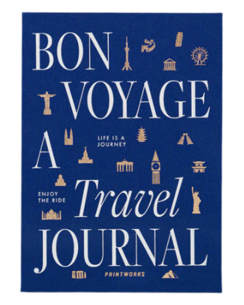 The PrintWorks Bon Voyage Travel Journal features a blue cover with white and gold “Bon Voyage A Travel Journal” text and landmark icons including the Eiffel Tower and Statue of Liberty.
