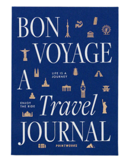 The PrintWorks Bon Voyage Travel Journal features a blue cover with white and gold “Bon Voyage A Travel Journal” text and landmark icons including the Eiffel Tower and Statue of Liberty.