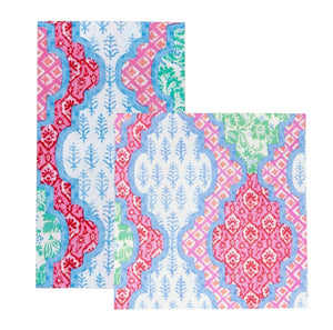 The Caspari Provencale Cotton Pink Multi Collection features colorful geometric and floral rugs in red, blue, green, and pink on white—adding charm to any room—and pairs perfectly with compostable napkins for eco-friendly gatherings.