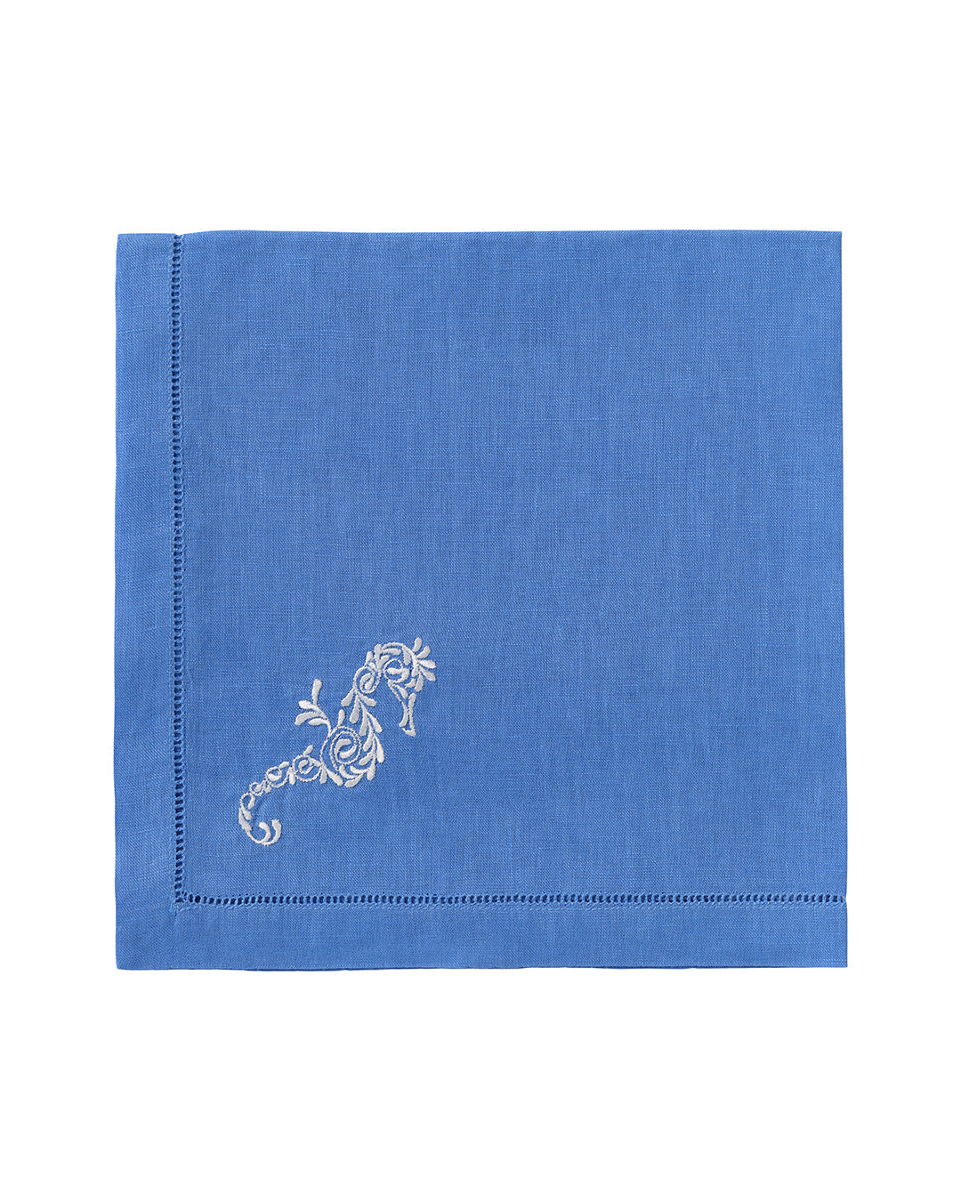 The Dinner Napkin Set by Pink House Mustique features blue linen napkins with white floral embroidery in one corner and a decorative stitched border—an elegant addition to your luxury table linens.