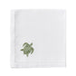 The Dinner Napkin Set by Pink House Mustique features white cloth napkins with a stitched border and a small green embroidered turtle, adding charm to your table—ideal for those seeking luxury or unique embroidered napkins.