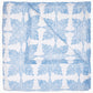 The Jaya Azure Bedding Collection by John Robshaw features a folded white cotton voile blanket with a blue floral starburst block print, displayed flat against a white background. Final Sale.