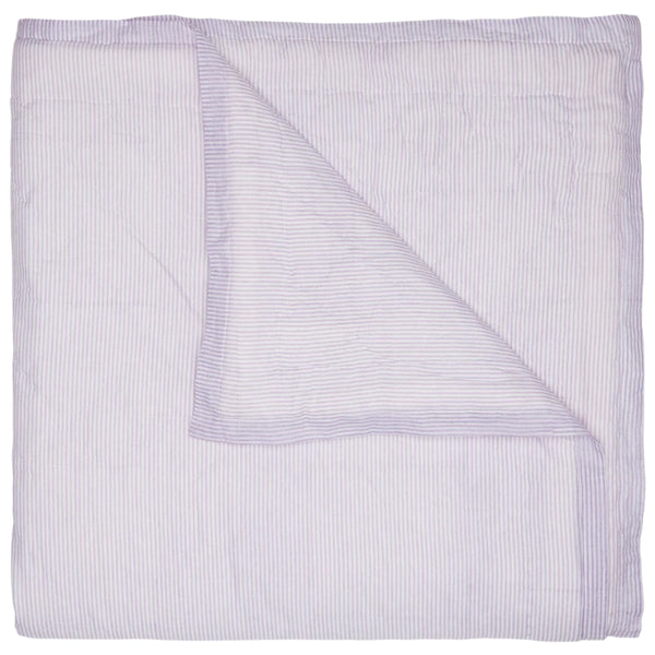 A folded John Robshaw Nandi Coverlet in lavender, with light purple and white stripes, features a turned-down corner and is crafted from soft cotton voile.