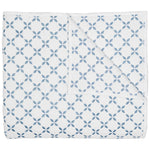 Introducing the Layla Bedding Collection by John Robshaw: a folded white quilt adorned with a repeating pattern of blue interlocking circles and four-petal flower motifs, inspired by the timeless elegance of Mughal gardens. Crafted from soft cotton voile, it’s the perfect bedding layer for year-round comfort.