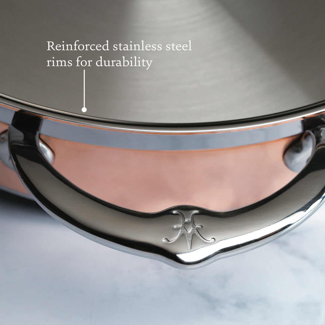 Close-up of the Hestan CopperBond 10-Piece Set handle with logo, showcasing its reinforced stainless steel rim and durable 5-ply construction—key features that define this premium cookware.
