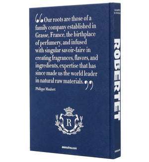 A blue hardcover book, "Robertet: From Seed to Scent" by Assouline, featuring a quote on Robertet's history and scent expertise by Philippe Maubert and a white crest below.