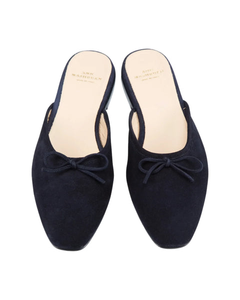 The Ann Mashburn Joy Mule shoes by Ann Mashburn are Italian-made black suede slip-on mules featuring small decorative bows on the front and beige insoles.