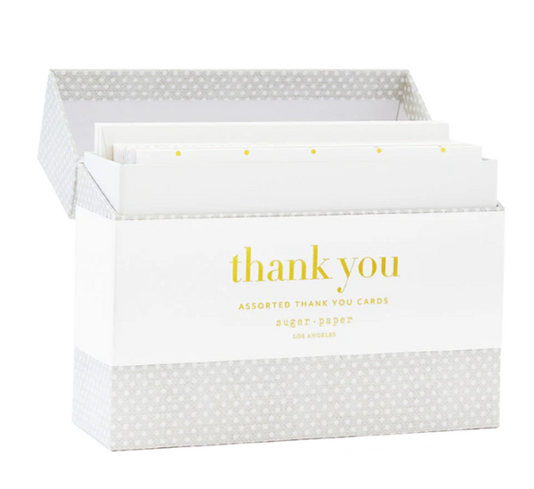 The Sugar Paper Thank You Card Box Set includes a delightful assortment of thank you cards, showcasing a charming polka dot design with "thank you" beautifully highlighted in gold foil on the front.