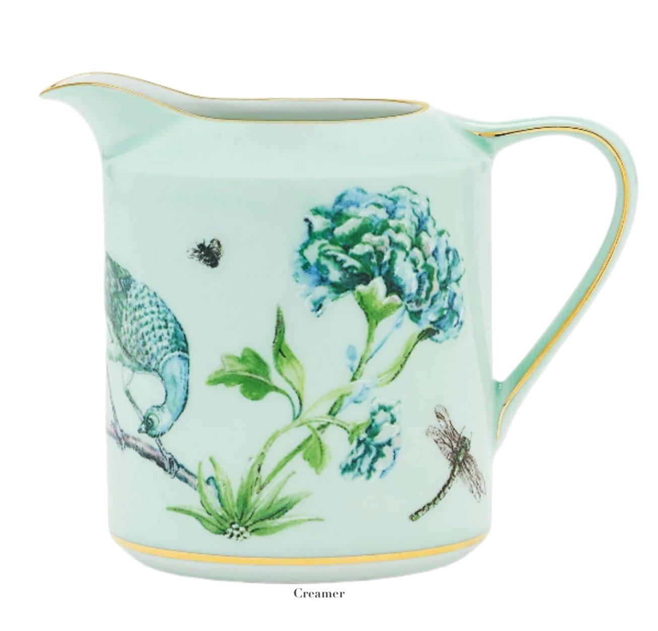 This light green ceramic creamer from the Aquazzura Secret Garden Collection by Aquazzura Casa features a garden motif adorned with vibrant illustrations of blue flowers, a peacock, a bee, and a dragonfly.