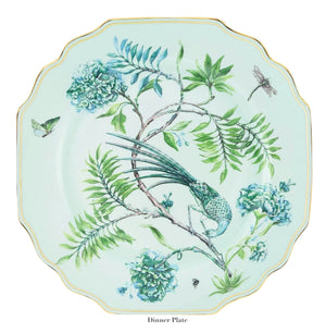 From the Aquazzura Casa Secret Garden Dinnerware and Serveware Collection, this porcelain dinner plate showcases a green bird, butterfly, dragonfly, blue-green flowers on a pale background with scalloped edge and gold details.