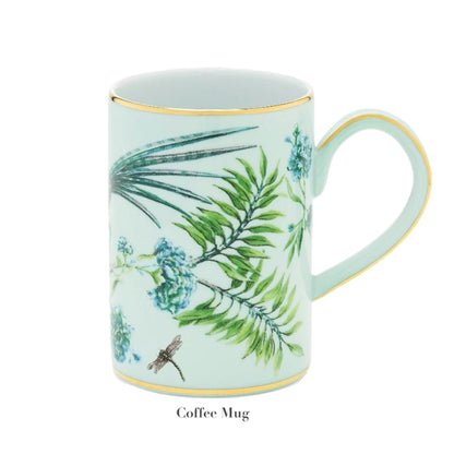 A light green coffee mug from the Aquazzura Secret Garden Collection by Aquazzura Casa showcases a garden-motif adorned with floral and dragonfly designs, elegantly enhanced with gold rims and handle.