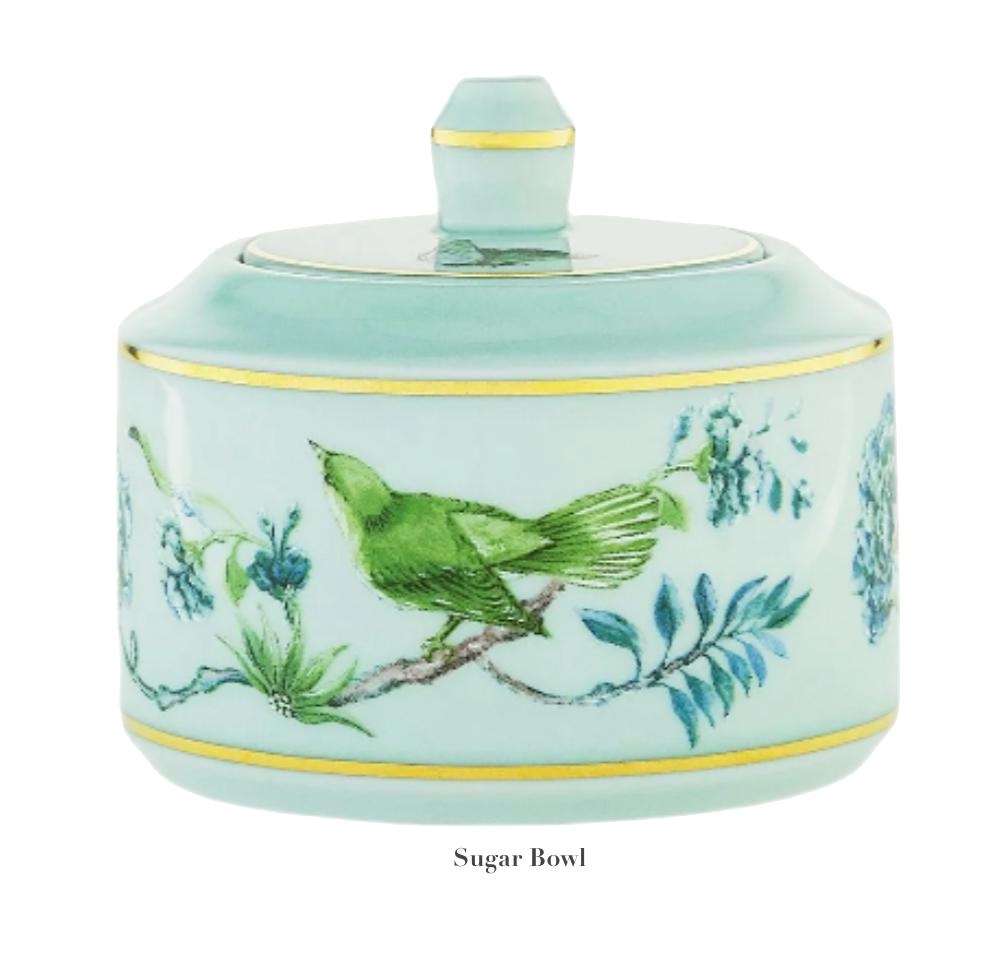 Porcelain sugar bowl with lid, adorned with a green bird and floral design on a light blue background, from the captivating Aquazzura Secret Garden Collection by Aquazzura Casa.