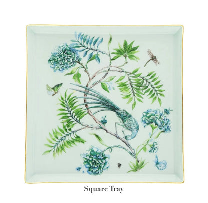 This square tray from the Aquazzura Secret Garden Collection by Aquazzura Casa showcases a garden-inspired design with a botanical print featuring a bird, dragonfly, butterfly, and blue flowers.