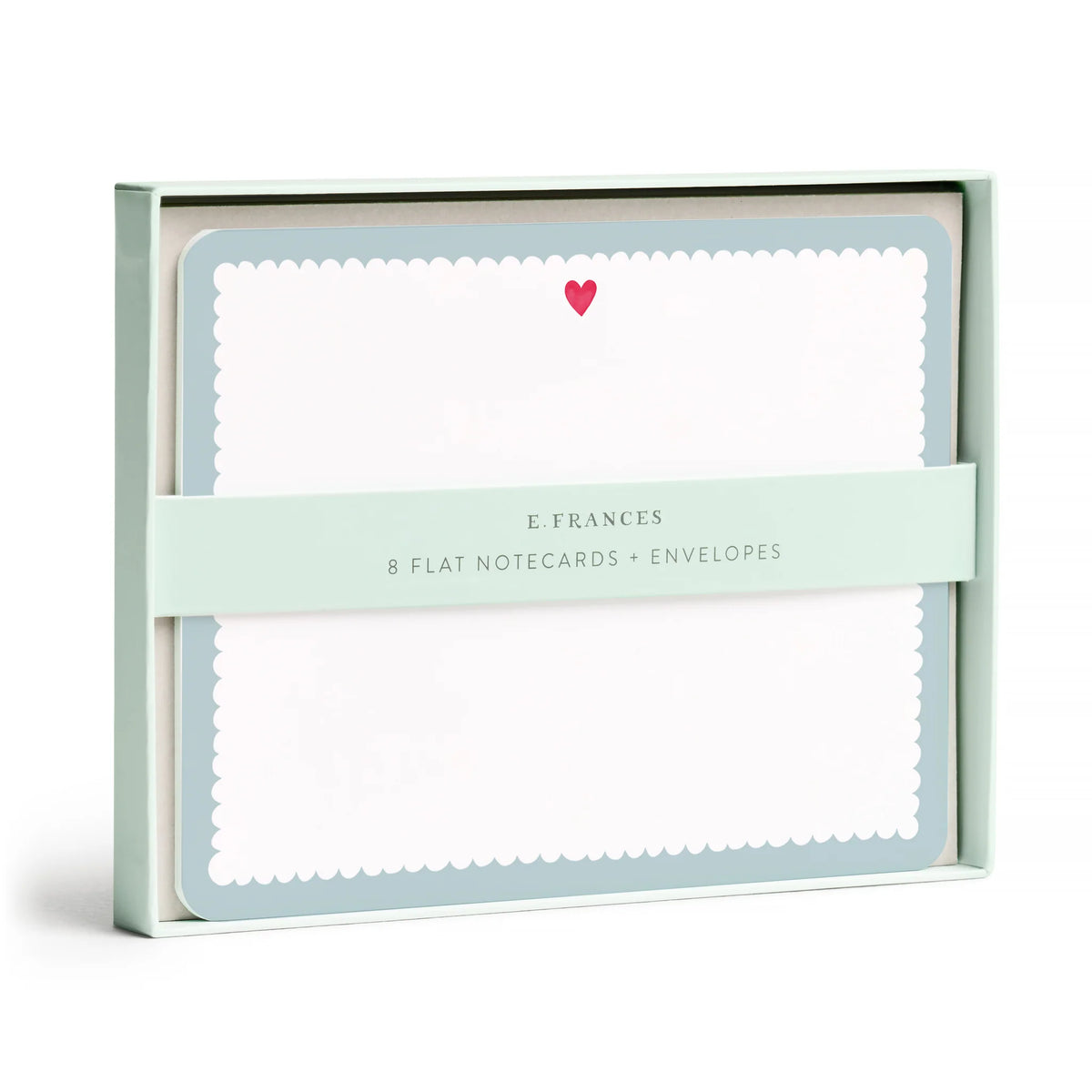 E. Frances Paper Notecard Sets featuring eight illustrated watercolor cards with scalloped blue edges and a small red heart, secured by a paper band.