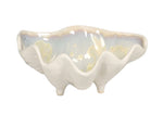 From AE Ceramics' Small Clam Bowl Collection, this white ceramic nut bowl features a wavy scalloped edge, three petite legs, and a glossy iridescent interior.