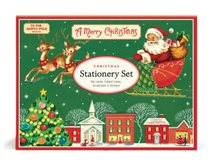 A vintage Cavallini Papers and Co. Christmas Stationery Set in a green box featuring Santa in a sleigh above a snowy village, including flat cards, folded notes, envelopes, and stickers.