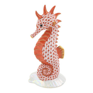 Herend's Seahorse on Scallop Shell is a porcelain collectible featuring a red and white patterned seahorse upright on an iridescent base—a timeless decorative accent for any space.