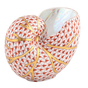 The Herend Nautilus Shell is a collectible porcelain vase featuring a red fish scale pattern and gold veining on white, showcasing timeless elegance.